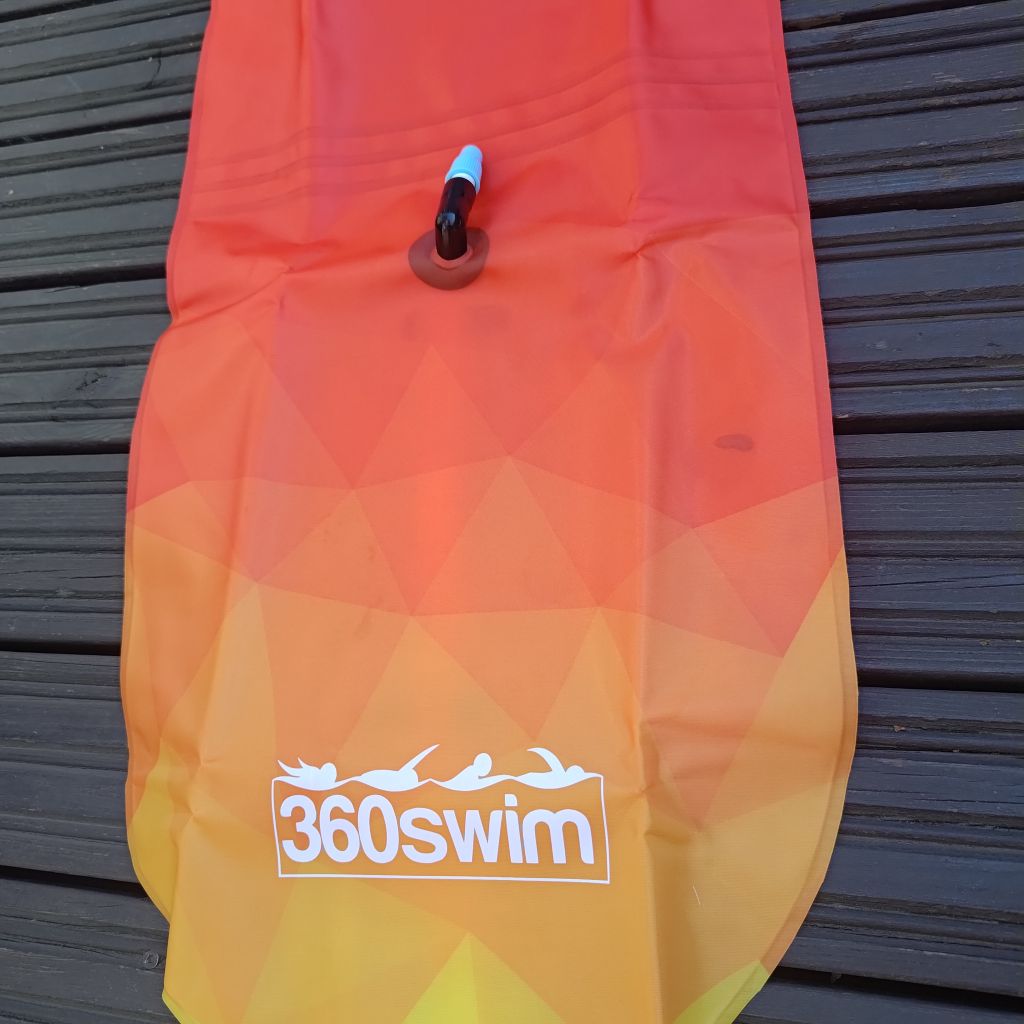 Orange-gelber Schwimmfloat mit 360swim-Logo auf Holzoberfläche